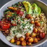 Wholesome Chickpea Power Bowl featuring crispy chickpeas, colorful roasted veggies, and fresh avocado slices drizzled with tahini.  