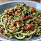 Healthy Easy Zucchini Noodle Stir-Fry with Peanut Sauce, featuring spiralized zucchini and crisp vegetables in a creamy, tangy peanut sauce.