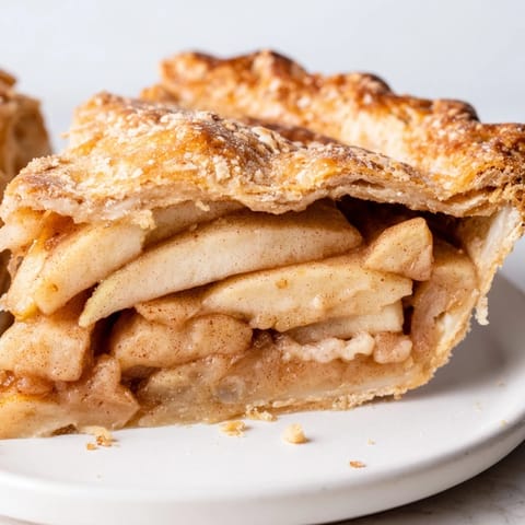 This classic American Apple Pie shows a beautiful, bubbly filling ready to enjoy warm.