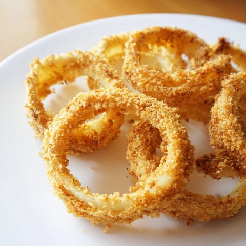 Golden, crispy onion rings freshly fried and ready to be dipped for a delicious appetizer.