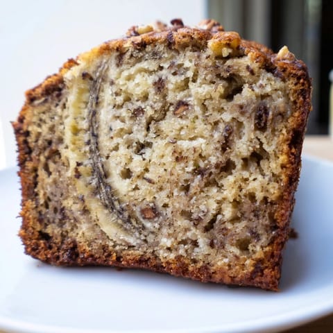 Warm, golden banana bread loaf fresh from the oven, offering a delicious, moist slice.