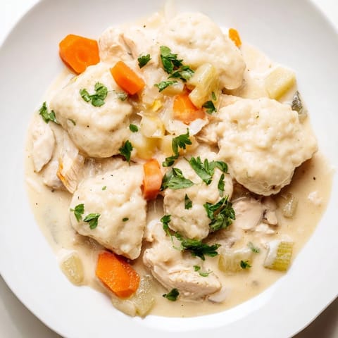 Close-up of hearty Chicken and Dumplings showcasing tender chicken and pillowy, homemade dumplings.