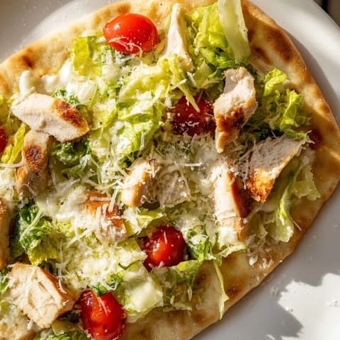Warm Chicken Caesar Flatbread with juicy chicken, crunchy romaine, and parmesan cheese for a quick lunch.  