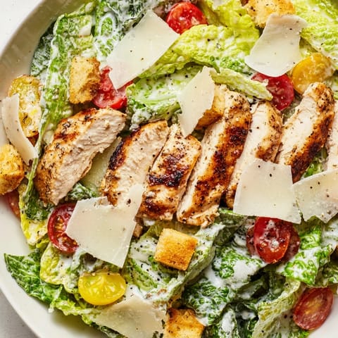 Crisp romaine lettuce tossed in a creamy Greek yogurt Caesar dressing, topped with tender grilled chicken strips and shaved Parmesan.