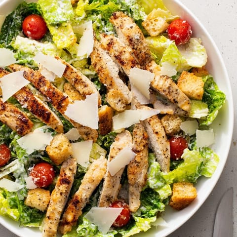 Freshly made yogurt Caesar grilled chicken salad, featuring juicy grilled chicken, crunchy croutons, and a light, tangy dressing.