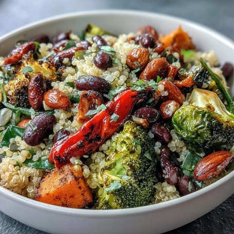 A colorful veggie and quinoa power bowl with roasted seasonal vegetables, black beans, and crunchy nuts drizzled with zesty lemon vinaigrette.